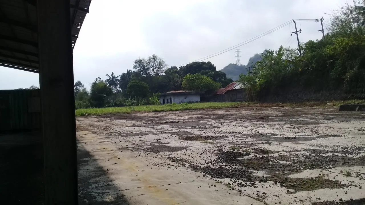 厂区混凝土硬化场地与开阔堆场，远处为山景